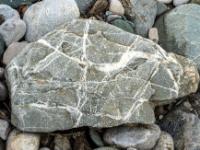 Größerer grauer Stein mit weißer kreuz und quer Maserung